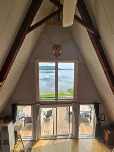 ein Zimmer mit einem großen Fenster im Dachgeschoss in der Unterkunft Chalet le Léandre in Cabano