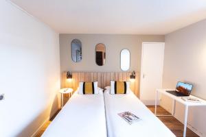 a bedroom with a large bed with two mirrors at Le Konine - Hotel & Bar & Restaurant in Montceau-les-Mines