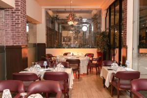 a restaurant with tables and chairs and a chandelier at Golden Carthage Hotel & Residence Tunis in Gammarth