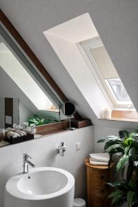 a bathroom with a white sink and a skylight at Vier Jahreszeiten Hotel in Husum