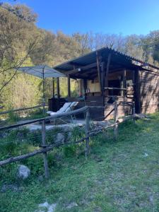 a wooden cabin with an umbrella in a field at Cabane in Olivese +5 photos