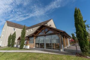 a large building with a wooden roof at Le Konine - Hotel & Bar & Restaurant in Montceau-les-Mines