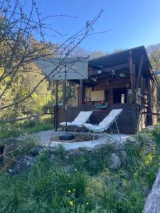 two chairs and an umbrella in front of a house at Cabane in Olivese