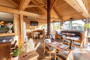 a restaurant with wooden walls and tables and chairs at Le Konine - Hotel & Bar & Restaurant in Montceau-les-Mines