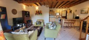 a living room with a couch and chairs and a table at Clarents Cottage in Somerset West