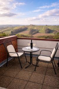 a table with two chairs and a bottle of wine on a balcony at Taverna & Wine Jeruzalem in Ivanjkovci