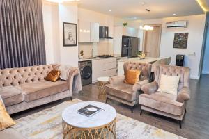 a living room with two couches and a kitchen at Jimi Comfort Stay in Bamgbose