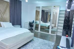 a bedroom with a bed and a large mirror at Jimi Comfort Stay in Bamgbose