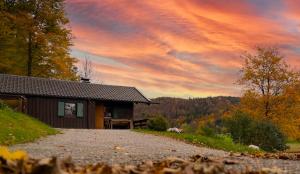 a house on a gravel road in front of a sunset at Romantisches Berg-Chalet in Bayrischzell