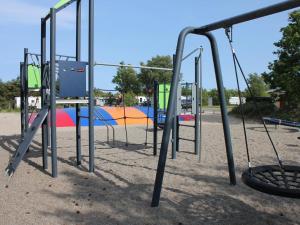 a group of swings in a playground at DCU-Camping Ålbæk Strand in Ålbæk