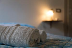 ein rollendes Handtuch auf dem Bett in der Unterkunft Abbraccio del Carrubo in Scicli