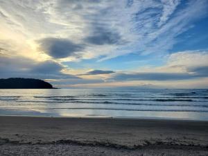 a beach with a cloudy sky and the ocean at RESORT HOTEL Ka (Adult Only) in Chosei
