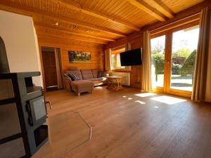 a living room with a couch and a tv at Unser Landhaus - Lastering Ferienhäuser & Apartments in Wettringen