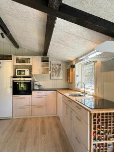 a kitchen with a white refrigerator and a sink at Summer House With Wilderness Bath By Kårup Forest in Fårevejle