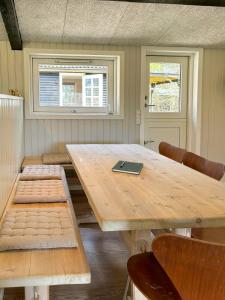 a wooden table with chairs and a laptop on it at Summer House With Wilderness Bath By Kårup Forest in Fårevejle