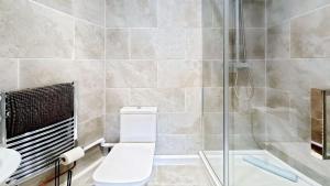 a bathroom with a toilet and a shower at The Saddlery in Sewerby