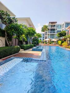 a swimming pool in the middle of a building at Vimanlay 84m style balinais - 2 chambres - plage, piscines in Cha Am