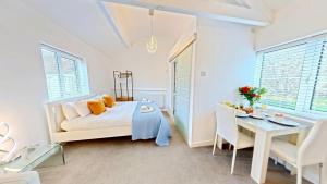 a white bedroom with a bed and a table at The Saddlery in Sewerby +9 photos