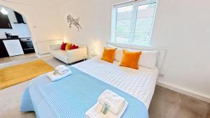 a bedroom with a blue and white bed and a couch at The Saddlery in Sewerby