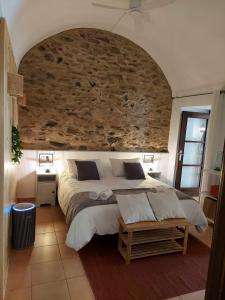 a bedroom with a large bed with a stone wall at La bóveda in Zafra