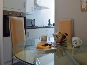 a glass table in a kitchen with a plate of food at Crossburn Hideaway in Helensburgh