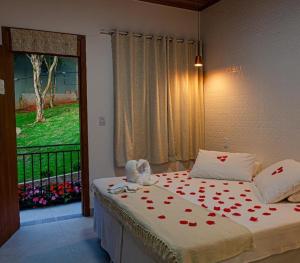 a bedroom with a bed with red hearts on it at Chalé Vila Catarina in Ouro Preto