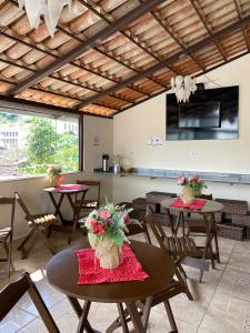 a dining room with tables and chairs with flowers on them at Chalé Vila Catarina in Ouro Preto