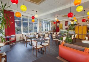 a restaurant with tables and chairs and windows at Hôtel Panoramic et des Bains in Luz-Saint-Sauveur