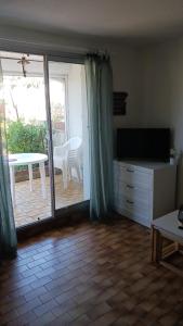 a living room with a sliding glass door with a table at Appartement t2 terrasse, jardin in Cap d'Agde