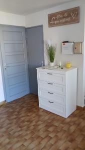 a room with two doors and a dresser with a plant on it at Appartement t2 terrasse, jardin in Cap d'Agde