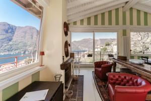 a room with a view of the water and mountains at Le Vetrate sul Lago Lake Como Amazing View in Nesso