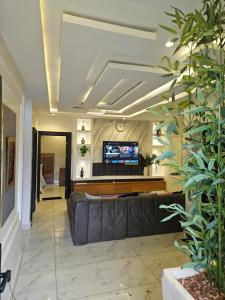 a living room with a couch and a tv at Less2More Luxury Suites in Agege