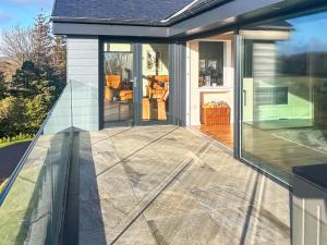 an extension of a house with glass doors and a patio at Grey Rocks House in Kippford