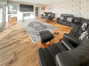 a living room with black furniture and a wooden floor at Grey Rocks House in Kippford
