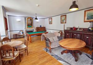 a living room with a ping pong table and chairs at Hôtel Panoramic et des Bains in Luz-Saint-Sauveur