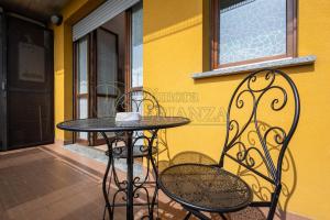 a table and chairs sitting next to a yellow wall at LT Dimora Brianza in Bovísio-Masciago Milanese