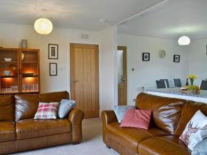 a living room with two brown leather couches at Summit in Oban