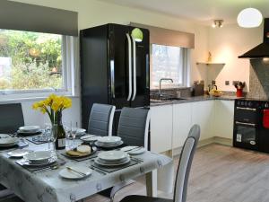 a kitchen with a table with chairs and a black refrigerator at Summit in Oban