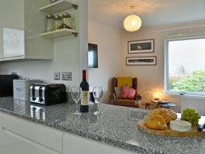 a kitchen with a counter with wine glasses and bread at Summit in Oban