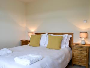 a bedroom with a white bed with two night stands at Summit in Oban +14 photos