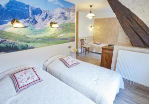 a bedroom with two beds and a painting on the wall at Hôtel Panoramic et des Bains in Luz-Saint-Sauveur +32 photos