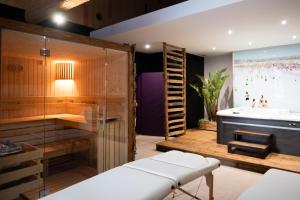 a bath room with a tub and a bath tub at Hôtel de Castigno - Wine Hotel & Resort in Assignan +55 photos