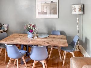 a wooden table with chairs and a vase of flowers at Campbells Stables in Berwick-Upon-Tweed