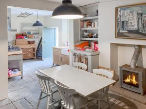 a kitchen with a table and a fireplace at Campbells Stables in Berwick-Upon-Tweed
