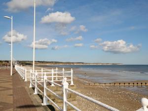 a white fence on a beach near the water at The Bait Shed in Filey