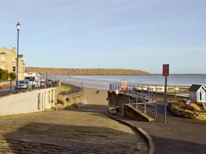 a view of a beach with people walking on the sand at The Bait Shed in Filey +11 photos