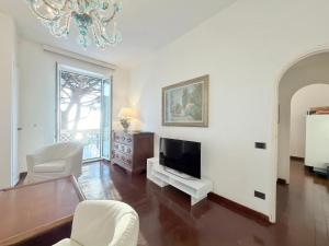 a living room with a television and a chandelier at VILLA MARE BLU in Levanto