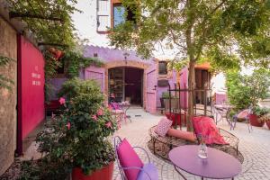 a patio with tables and chairs in a courtyard at Hôtel de Castigno - Wine Hotel & Resort in Assignan