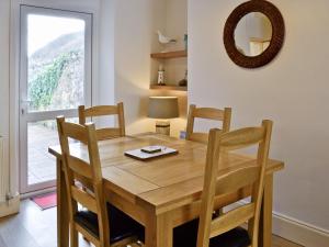 a wooden dining room table with chairs and a window at Castle Street in Criccieth