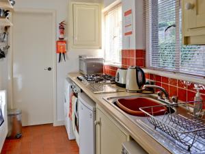 a kitchen with a sink and a stove at Castle Street in Criccieth +2 photos